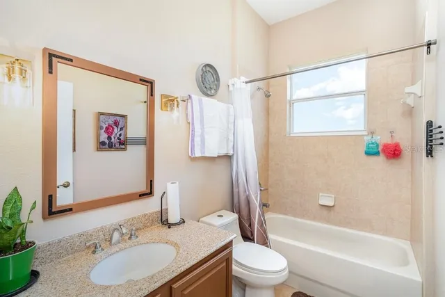 a bathroom with a granite countertop sink mirror vanity and toilet