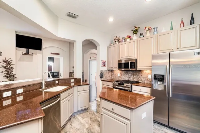 a kitchen with stainless steel appliances granite countertop a sink refrigerator and microwave