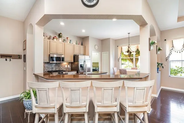 a kitchen with stainless steel appliances kitchen island granite countertop a table and chairs in it