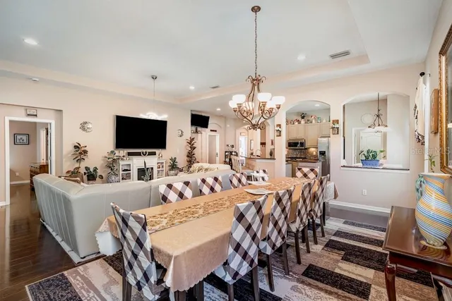 a living room with furniture a flat screen tv and a chandelier