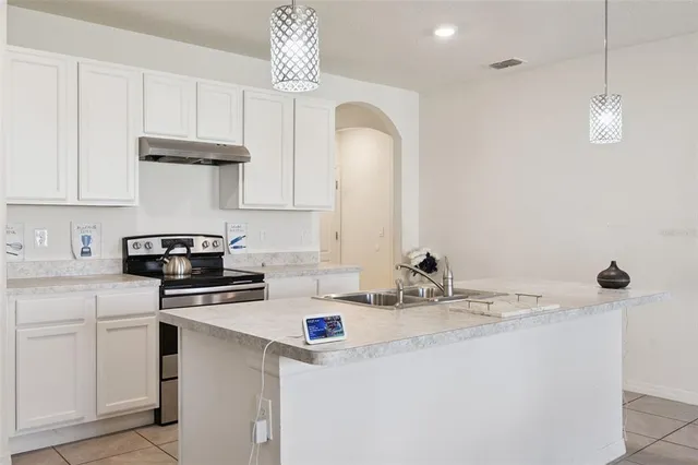 a kitchen with stainless steel appliances a sink a stove and cabinets