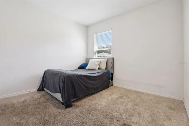 a spacious bedroom with a bed and a night stand