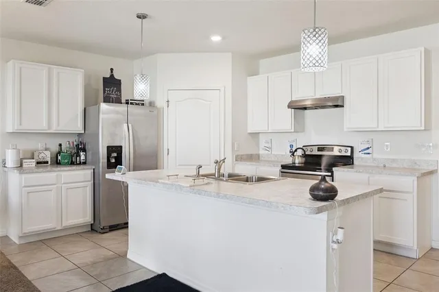 a kitchen with kitchen island granite countertop a sink stainless steel appliances and cabinets