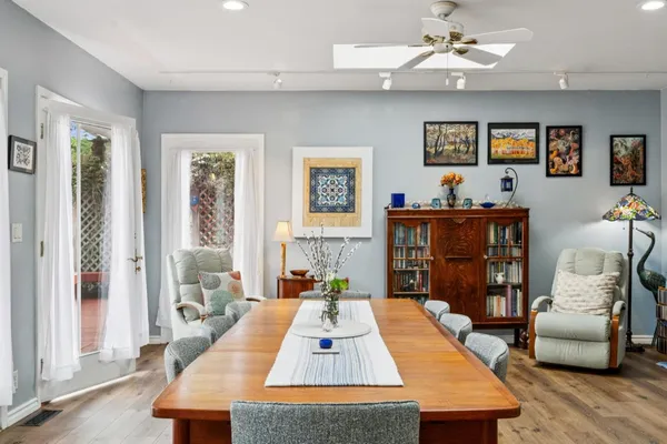 a dining hall with stainless steel appliances kitchen island granite countertop a dining table and chairs