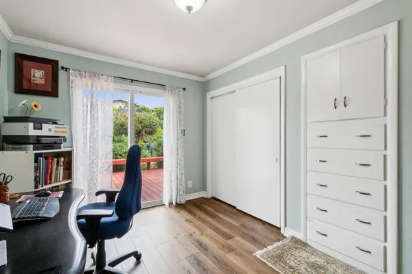 a bedroom with a bed a painting on the wall and a window