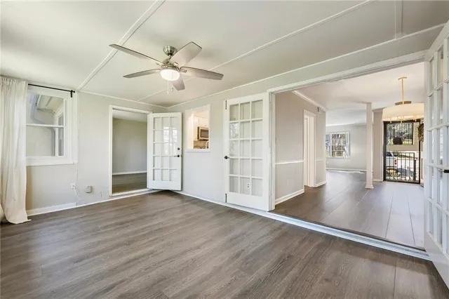 a view of an empty room with window and wooden floor