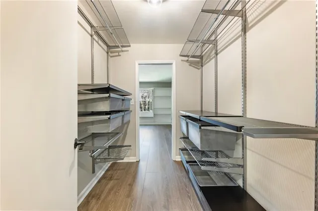 a view of walk in closet with clothes and shoes