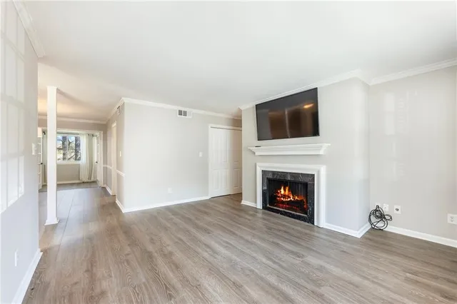 a view of a livingroom with wooden floor and a fireplace