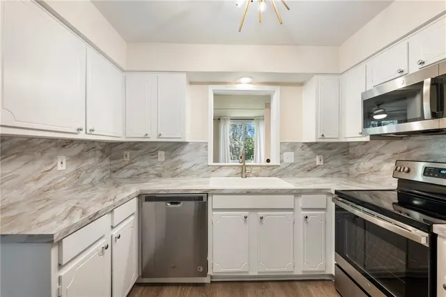 a kitchen with stainless steel appliances granite countertop a sink and a stove