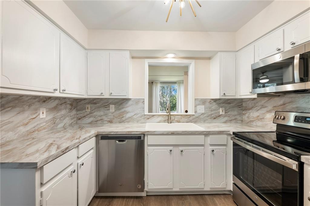 162 Amherst Place Northwest Atlanta, GA 30327 - Photo 7 of 24 a kitchen with stainless steel appliances granite countertop a sink and a stove