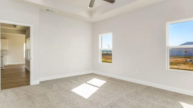 an empty room with a window and a ceiling fan