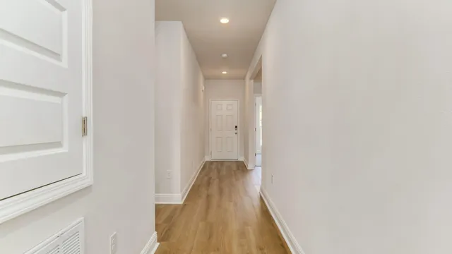 a view of a hallway with wooden floor