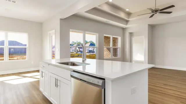 a dining hall with stainless steel appliances granite countertop a sink and dishwasher with wooden floor