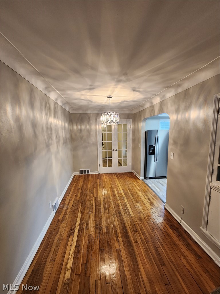 2199 North Taylor Road Cleveland Heights, OH 44112 - Photo 8 of 19 Empty room featuring french doors, hardwood / wood-style flooring, and a chandelier