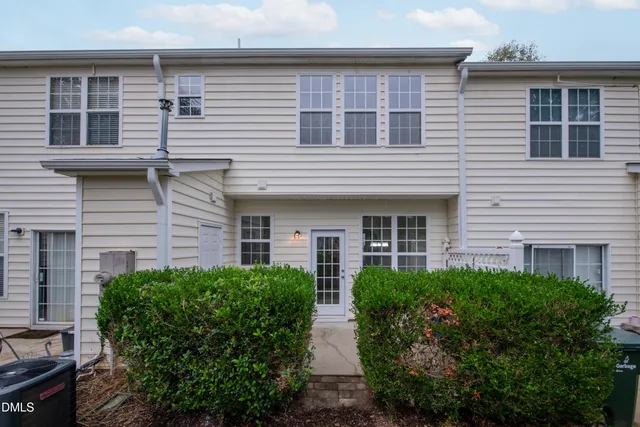 a view of a house with potted plants and a garage