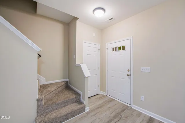 an empty room with wooden floor and entrance