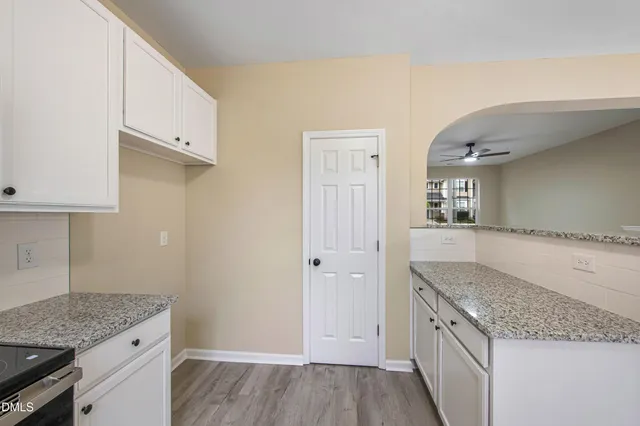 a kitchen with granite countertop a sink a stove and cabinets