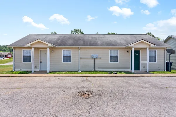 a front view of a house with a yard and trees