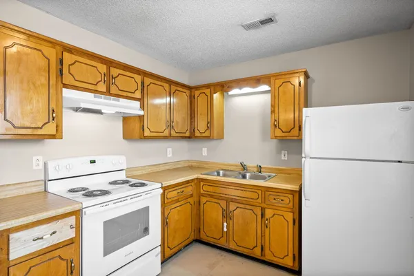 a kitchen with a sink a refrigerator and cabinets