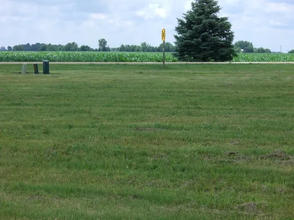 a view of a green field with wooden fence