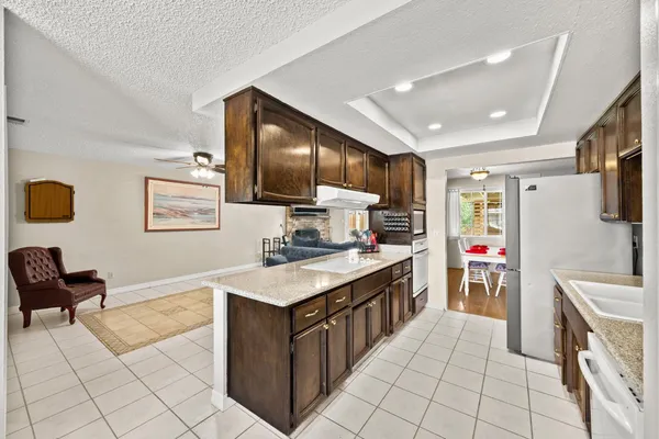a kitchen with kitchen island granite countertop a sink counter top space appliances and cabinets