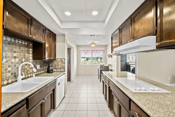 a large kitchen with stainless steel appliances granite countertop a sink and stove