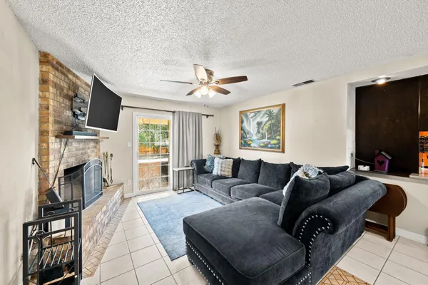 a living room with furniture a fireplace and a flat screen tv