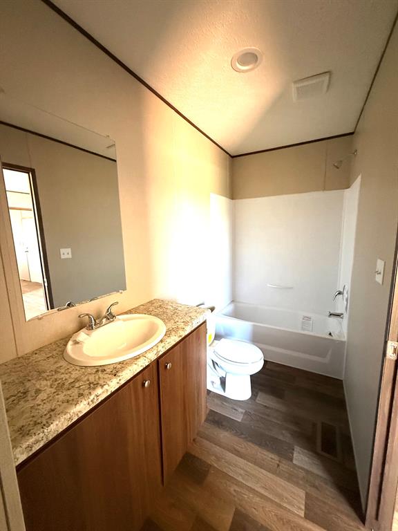 0 Southeast 4060 Road, Unit 25 Kerens, TX 75144 - Photo 9 of 18 Bathroom featuring a wood-finish vanity with a light speckled countertop, an oval undermount sink, and a chrome faucet