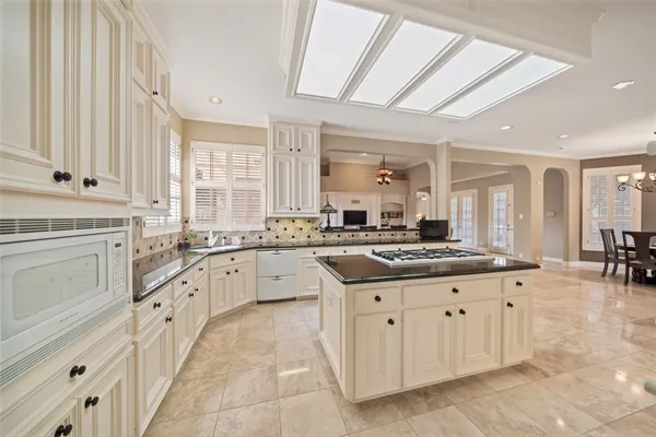 a large white kitchen with wooden floor and a sink