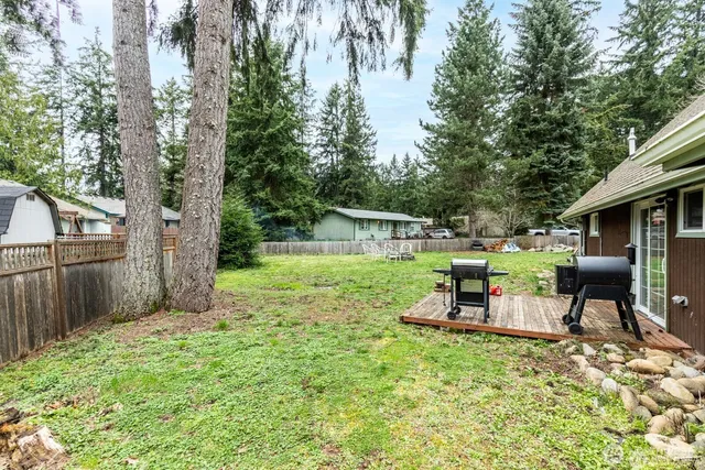 a view of a chair and table in backyard of the house