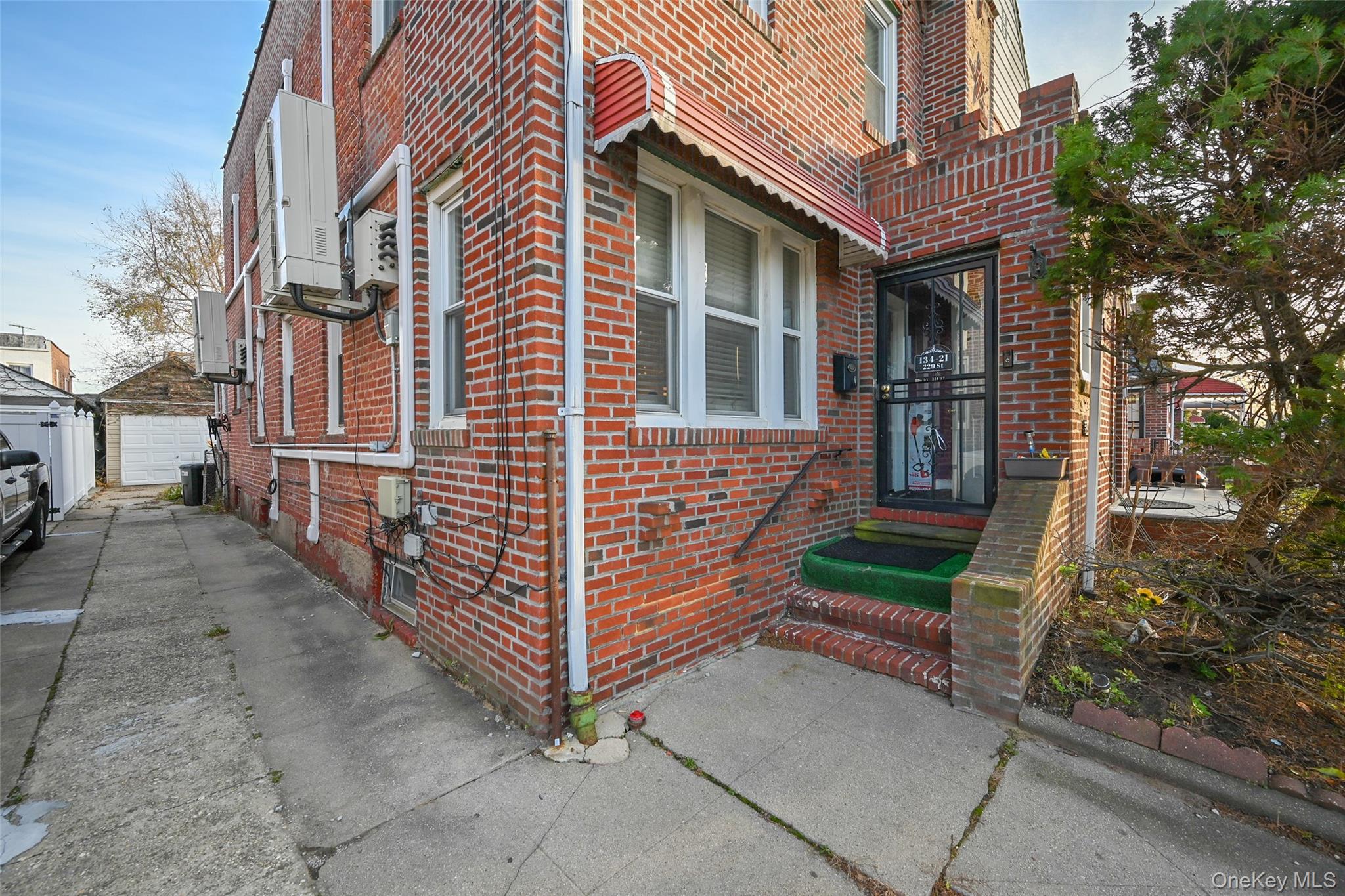 134-21 229th Street Queens, NY 11413 - Photo 19 of 25 a front view of a house with a yard