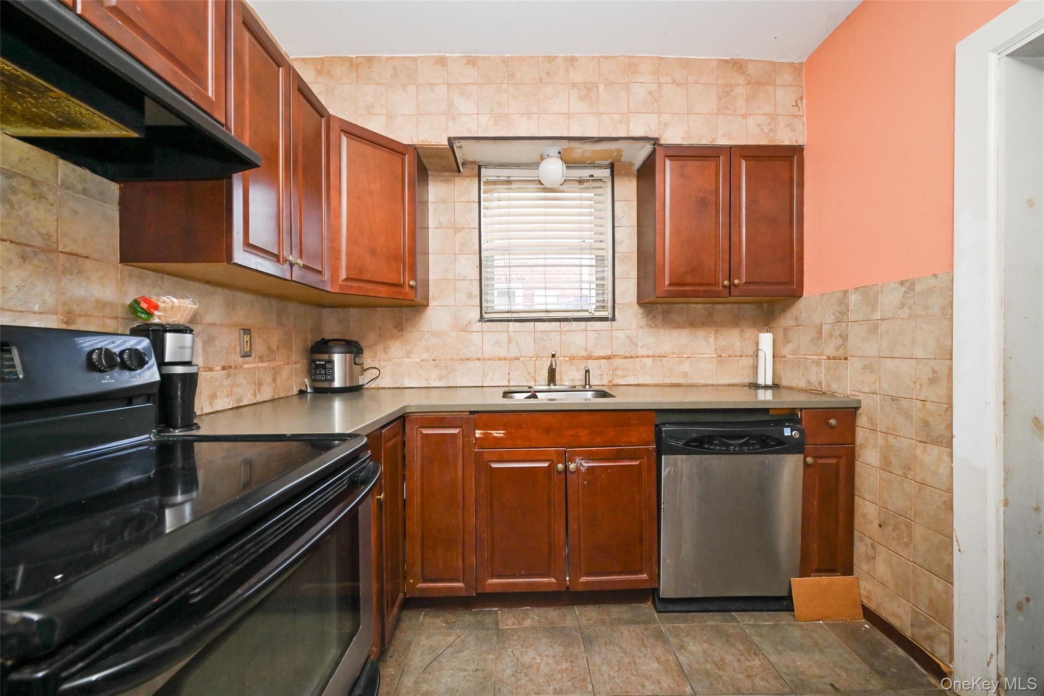134-21 229th Street Queens, NY 11413 - Photo 6 of 25 a kitchen with stainless steel appliances granite countertop a sink stove and cabinets
