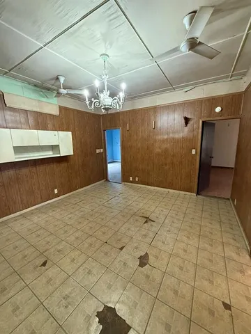 en empty room with windows and ceiling fan