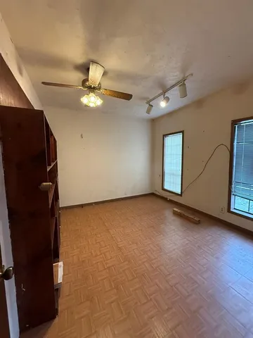 a view of an empty room with window and wooden floor
