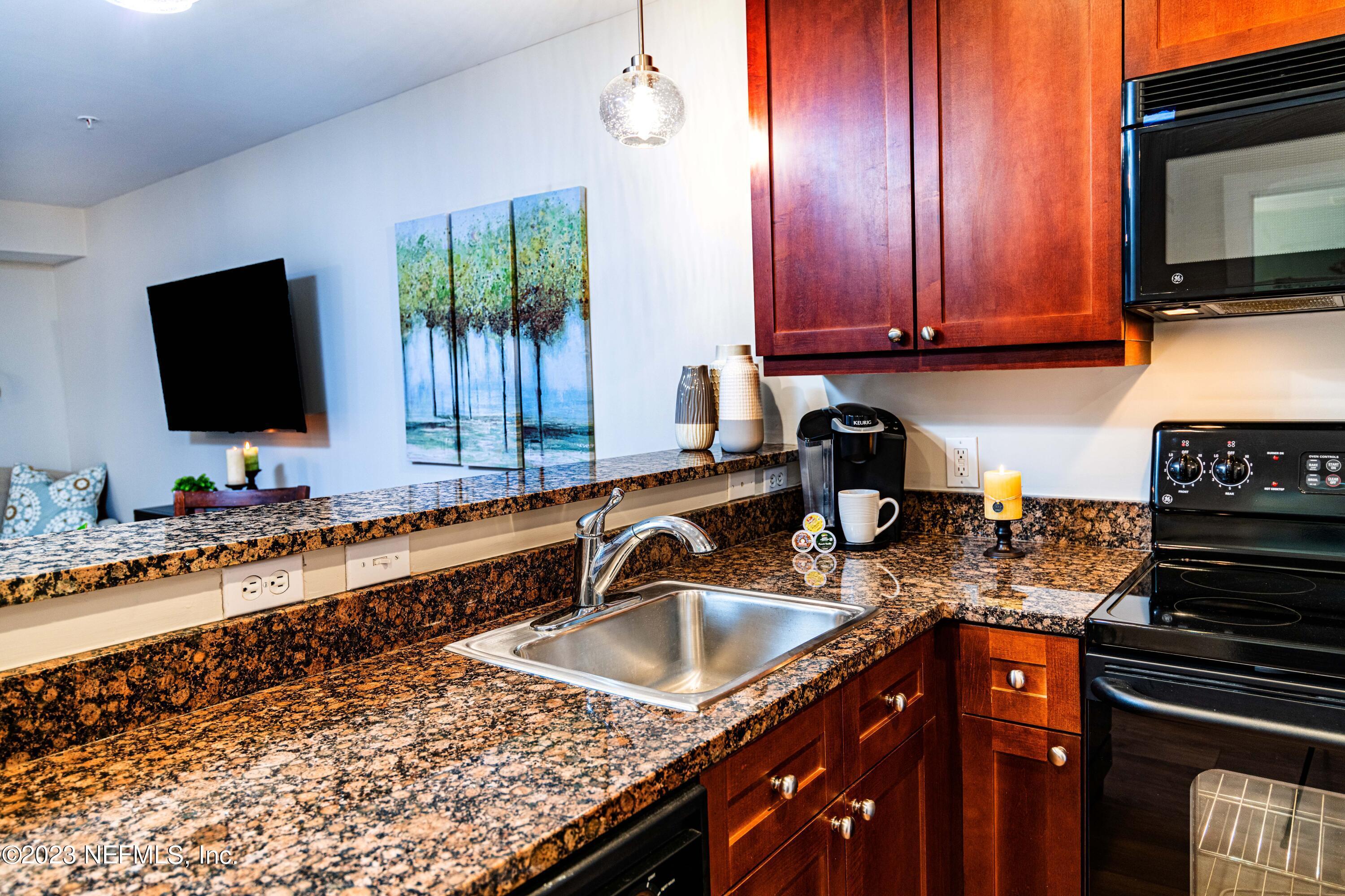955 Registry Boulevard, Unit 317 St. Augustine, FL 32092 - Photo 6 of 29 a kitchen with stainless steel appliances granite countertop a sink stove and microwave