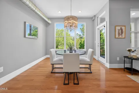 a dining room with furniture a large window and wooden floor