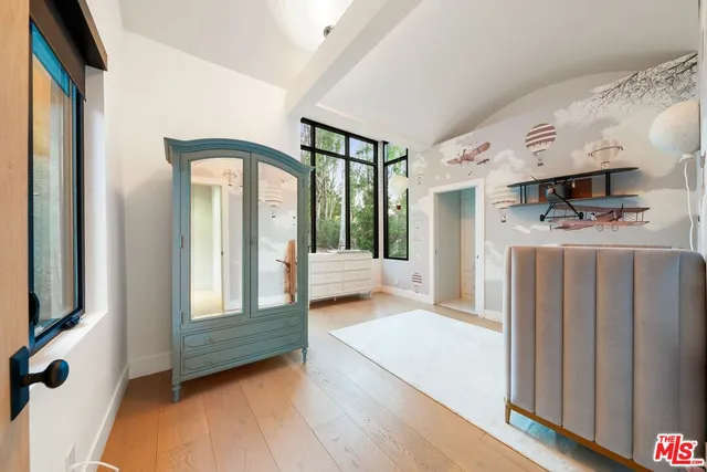 a view of a hallway with entryway and wooden floor