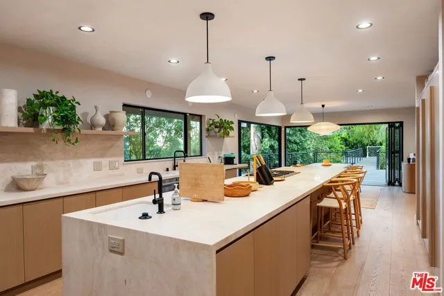 a view of a kitchen with kitchen island a sink and a large window