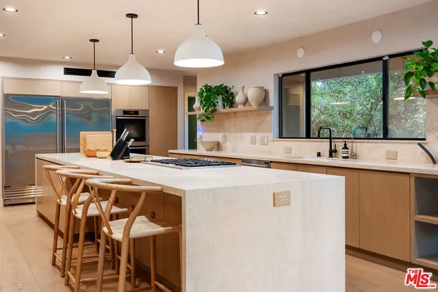 a kitchen with stainless steel appliances kitchen island a large window and cabinets
