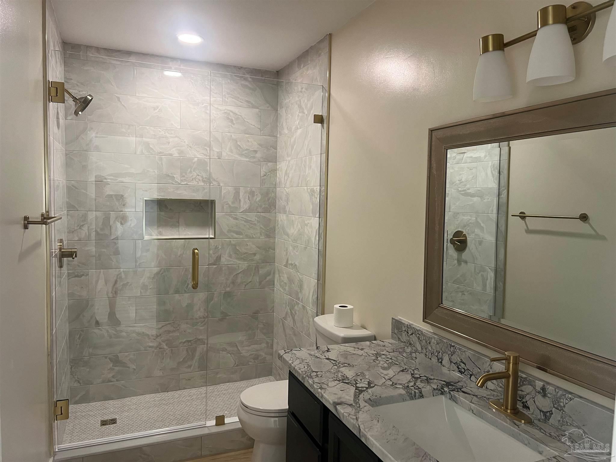 3111 Holley Point Road Navarre, FL 32566 - Photo 7 of 23 a bathroom with a granite countertop sink a toilet and shower