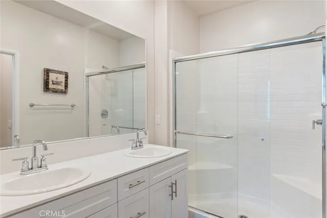 a bathroom with a granite countertop sink a shower and a mirror