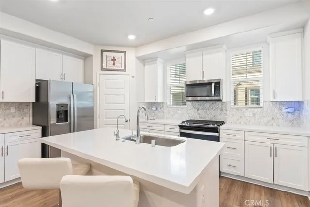 a kitchen with white cabinets and stainless steel appliances