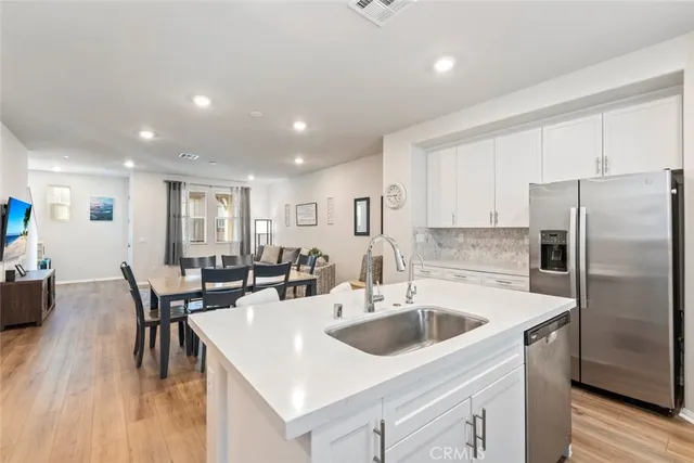 a kitchen with a sink a kitchen island and stainless steel appliances