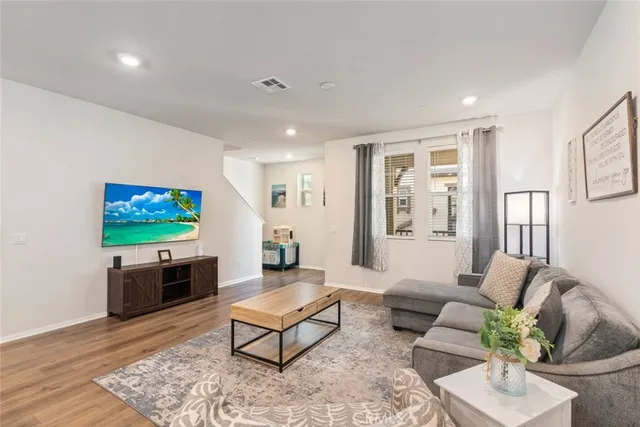 a living room with furniture a rug and a flat screen tv