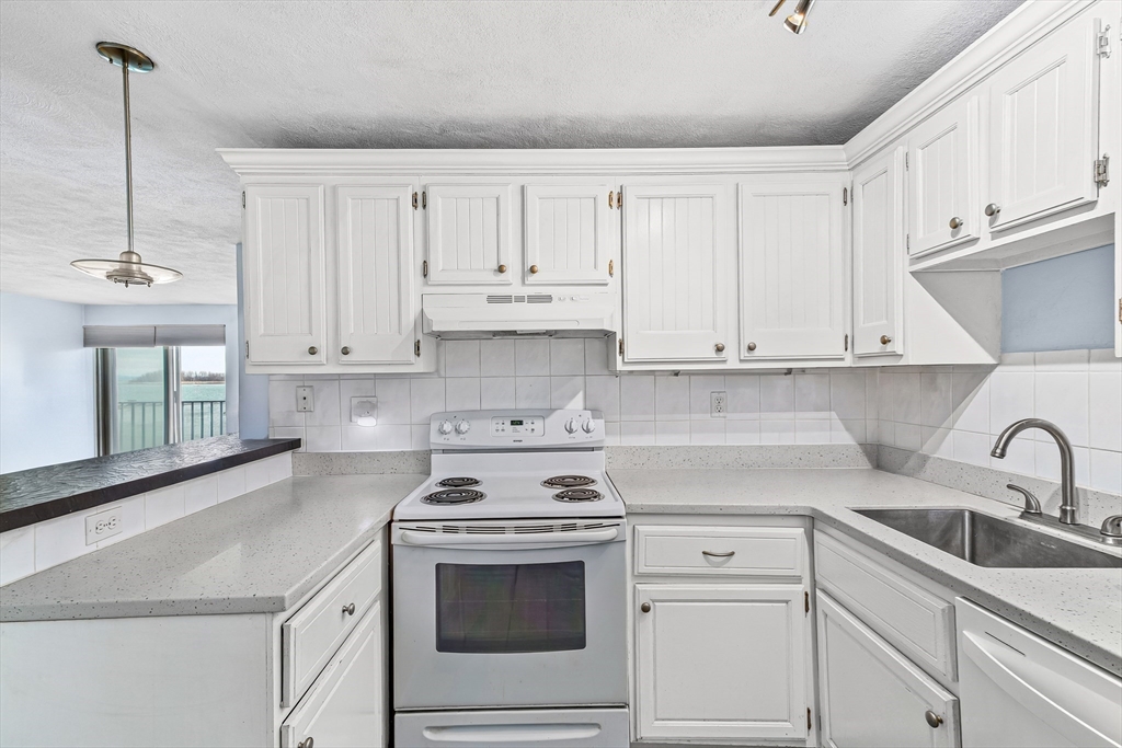 247 Washington, Unit 9 Winthrop, MA 02152 - Photo 4 of 18 a kitchen with white cabinets and white appliances