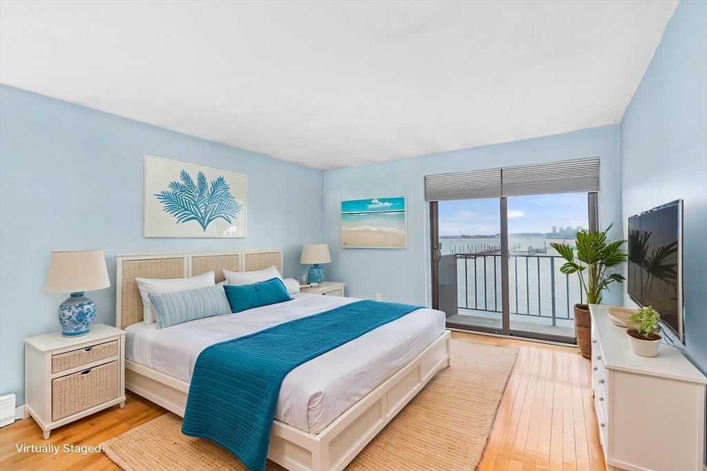 247 Washington, Unit 9 Winthrop, MA 02152 - Photo 8 of 18 a bedroom with a bed and a flat screen tv