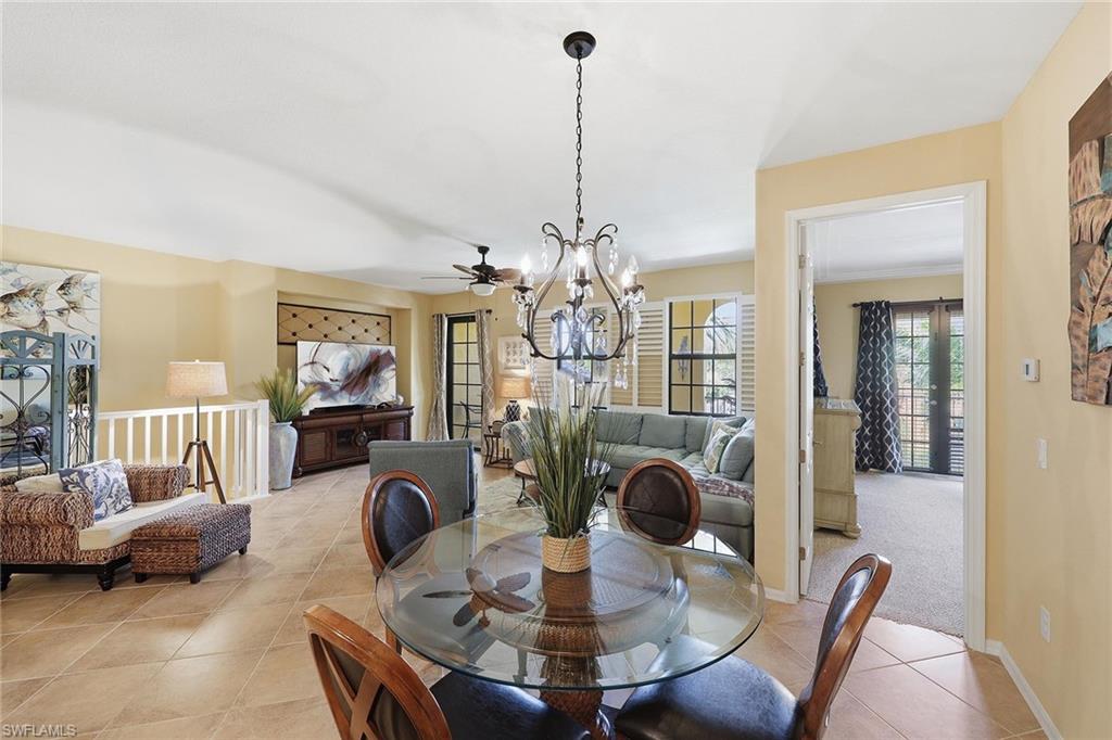8986 Cambria Circle, Unit 2204 Naples, FL 34113 - Photo 11 of 36 a living room with furniture a chandelier and a dining table