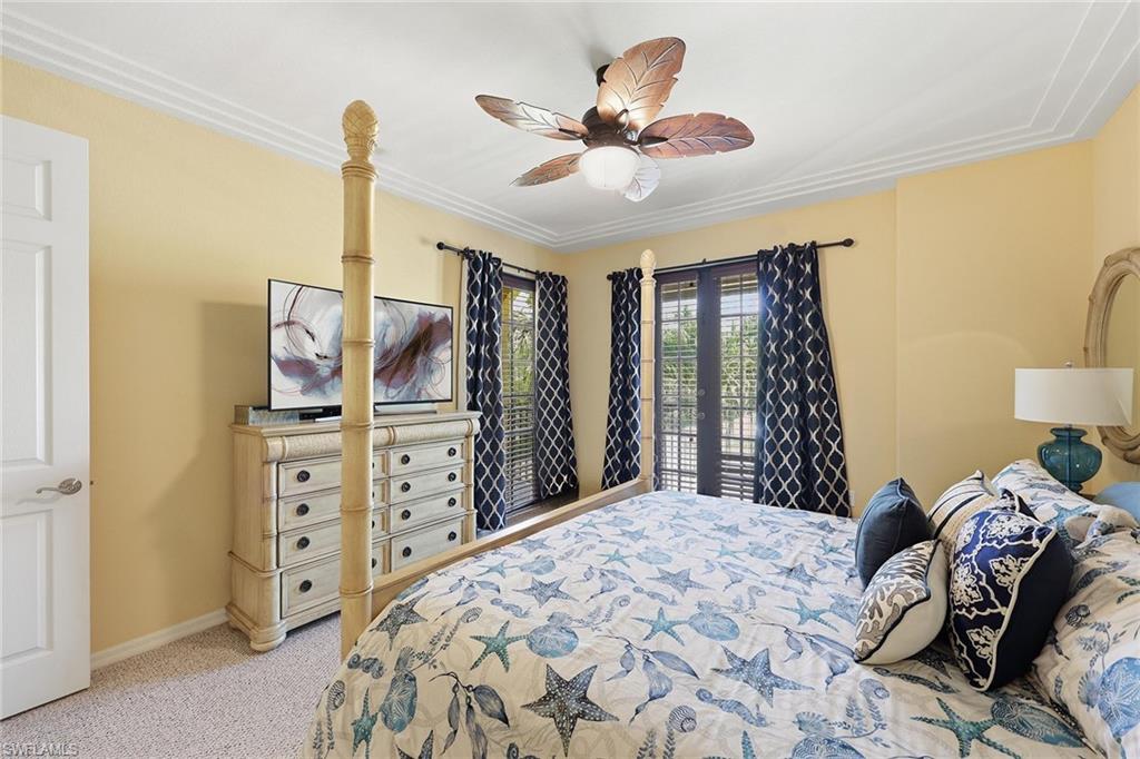 8986 Cambria Circle, Unit 2204 Naples, FL 34113 - Photo 13 of 36 a bedroom with a bed and a chandelier