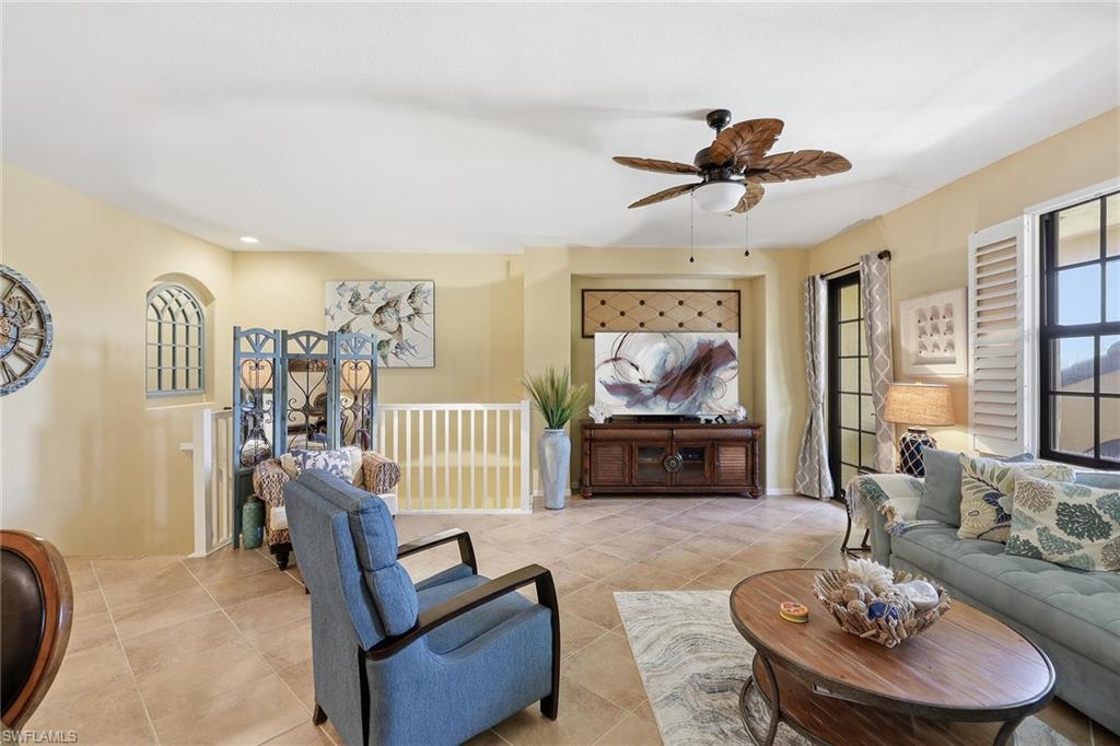 8986 Cambria Circle, Unit 2204 Naples, FL 34113 - Photo 16 of 36 a living room with furniture and a flat screen tv