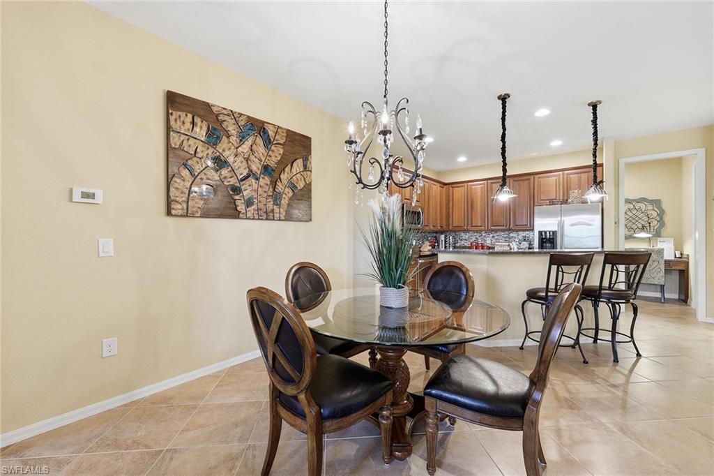 8986 Cambria Circle, Unit 2204 Naples, FL 34113 - Photo 7 of 36 a dining room with furniture and kitchen view